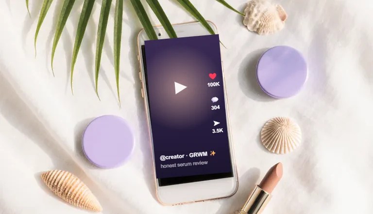 Ponsel menampilkan video review kreator, dikelilingi produk beauty, gaya flatlay Paradise Creative